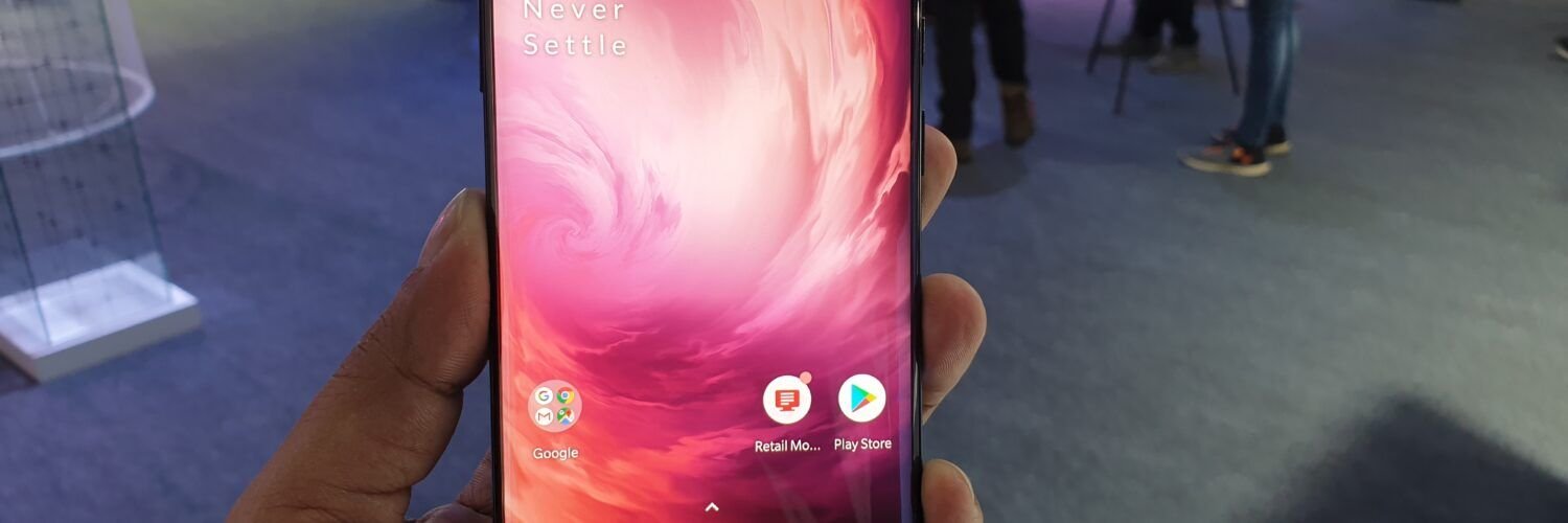 OnePlus 7 Pro smartphone photographed at its launch, illustrating a Qualcomm CrashDump troubleshooting guide.